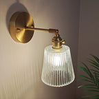 Lámpara de pared industrial de un luz con brazo oscilante de acabado en latón, pantalla de vidrio transparente