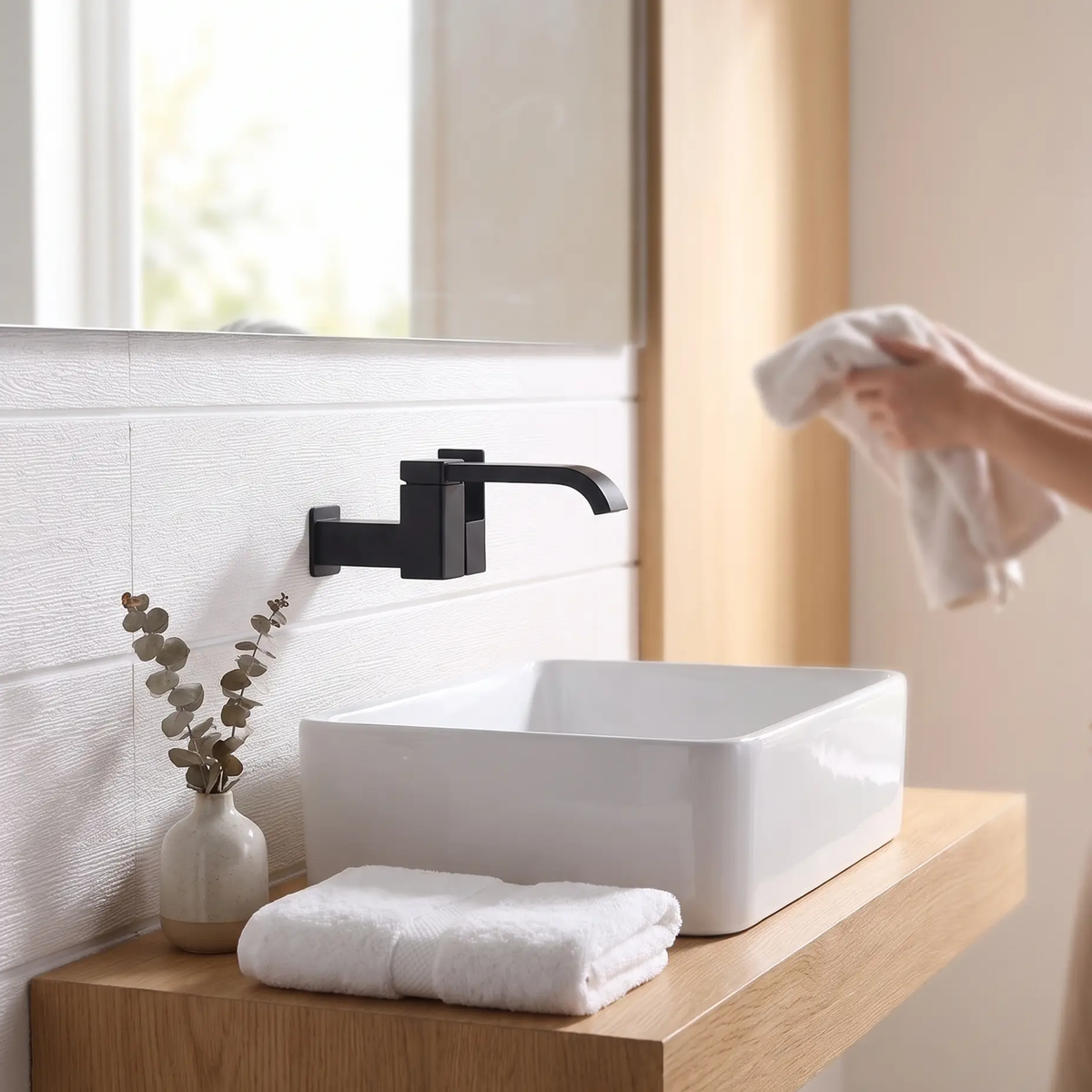 Grifo de baño contemporáneo montado en la pared con manijas de palanca y arco bajo de bronce