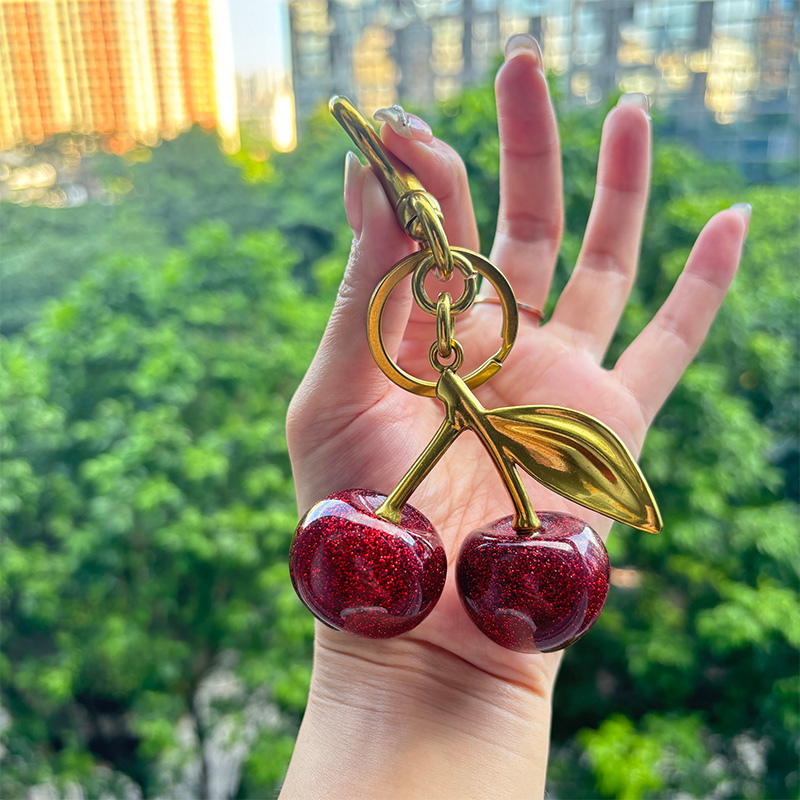 Llave de metal con colgante de cereza